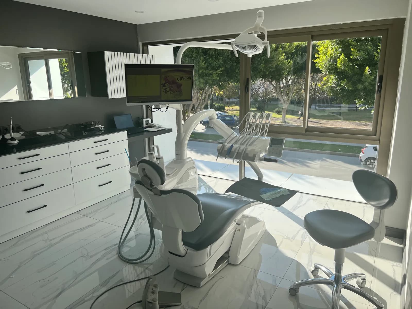 Salle de soins d'İZY Dentiste à Antalya, fauteuil dentaire face à une baie vitrée donnant sur la verdure